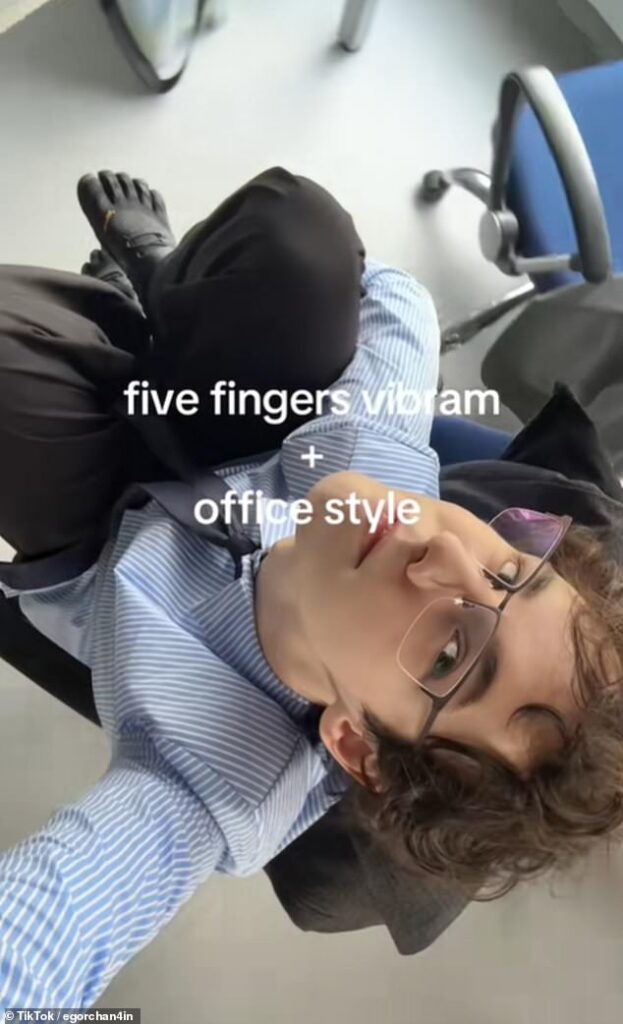 Fashion designer Egor Modelyer (pictured), from Moscow, filmed himself spinning around on a chair while wearing a black version of the bizarre five-fingered shoe while in the workplace