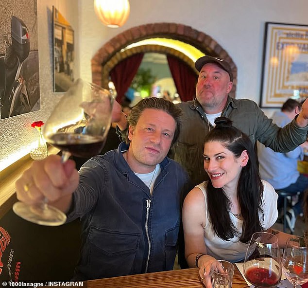 Celebrity chef Jamie Oliver dropped by 1800 Lasagne in 2023 with foodie pals Tobie Puttock (not pictured) and Georgie Puttock (right) and posed for a picture with the restaurant's founder Joey Kellock (back)