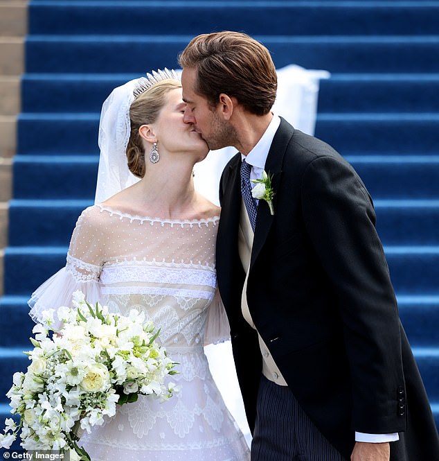 The happy couple (pictured) sealed their vows with a kiss on the steps of the cathedral after their wedding ceremony