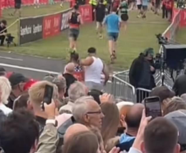 Tommy Fury appears to push a fellow runner out of his way near the finish line of the half marathon